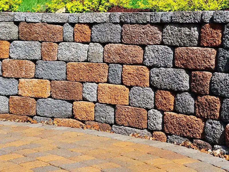 Multicolored interlocking retaining wall with textured block surface